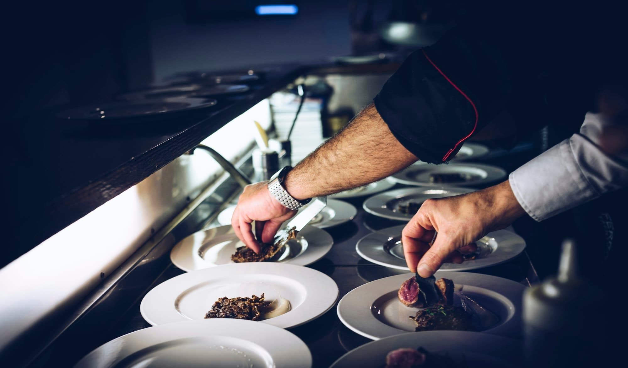 Uno chef impiatta al passe di un ristorante